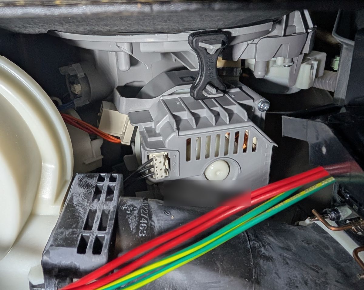 Underside of a Bosch 800 Series dishwasher with the lower panel off, showing the pump assembly and its wiring below the tub